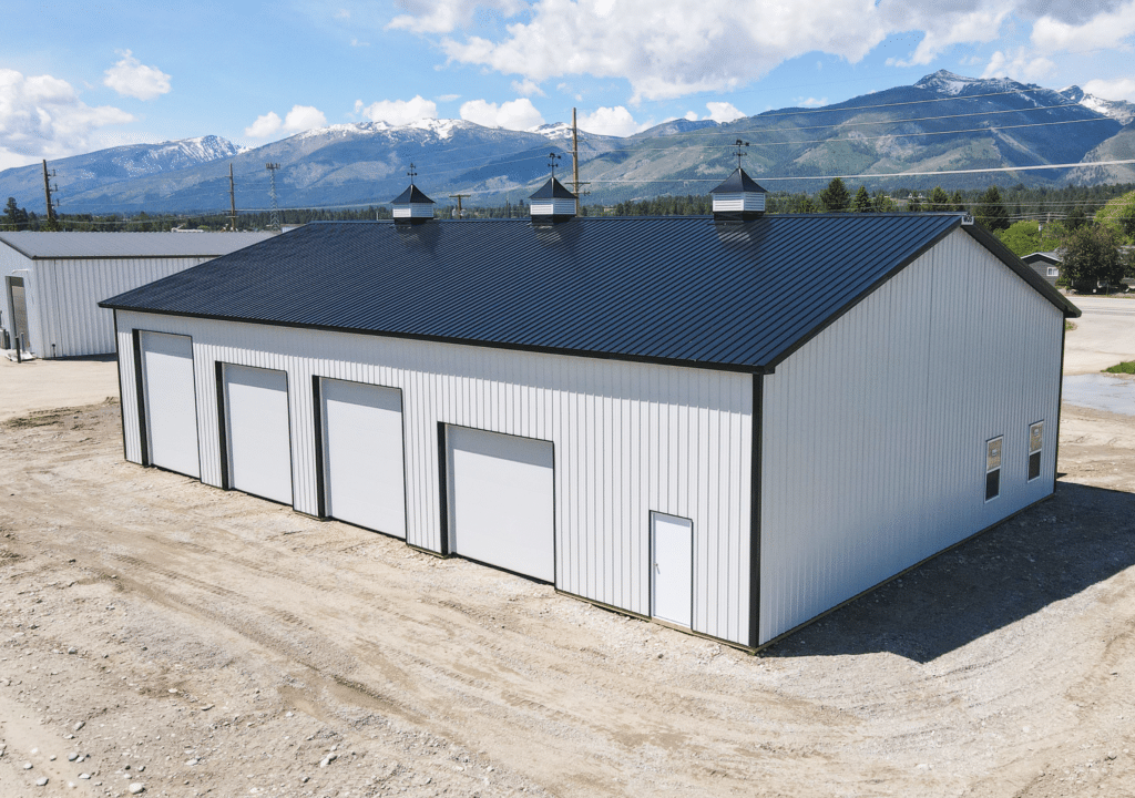 A medium commercial multipurpose garage, Built by MQS, featuring White metal siding, and black metal trim and roofing available for custom build in MT, ID, WA, & WY A medium commercial multipurpose garage, Built by MQS, featuring White metal siding, and black metal trim and roofing available for custom build in MT, ID, WA, & WY