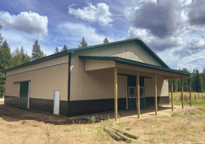 A 60x60x16 Indoor Riding Arena, with sidelight, built by MQS, featuring Tan Metal Siding, Evergreen Metal Trim and Roofing, in Newport, WA
