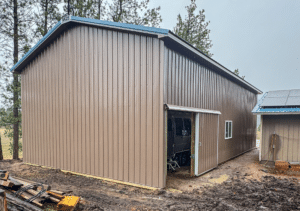 A 26x48x14 Open-Sided RV Storage Pole Barn, Built By MQS, With Desert Brown metal siding, and Hawaiian Blue metal roofing, in Bonner, MT