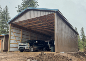A 26x48x14 Open sided RV Storage Pole Barn, Featuring Desert Brown metal siding, and Hawaiian Blue metal roofing, Built by MQS, in Bonner, MT