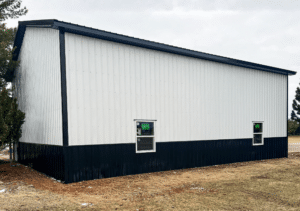 A 32x44x16 Hobby_Workshop Garage Residential Pole Barn, featuring white metal siding and black metal roofing, built by MQS, in Columbia Falls, MT