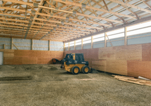 A 40x100x14 Hay and Ag Equipment Storage Interior, featuring rural red metal siding, and medium green metal roofing, Built By MQS in Kalispell, MT