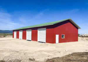 A 40x100x14 Hay and Ag Equipment Storage, featuring rural red metal siding, and medium green metal roofing, built by MQS, in Kalispell, MT