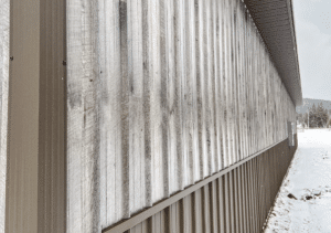 The Side of a 40x100x20 Multi-Stall Monitor Style Horse_Equine Equestrian Pole Barn, Built By MQS, featuring Distressed Gray Barnwood Metal Siding, and Burnished slate Roofing and wainscoting, in Elliston, MT