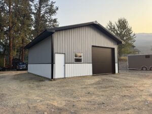 a single door hobby shop workshop garage with gray metal siding, black metal roofing and trim, and white metal wanscoting, available for custom order by MQS in Montana