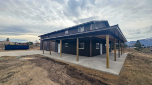 40x64x16 Bardominium_Garage shell, with Lean-Tos for a porch, Featuring Gray Metal Siding, Brown Metal Trim, And Black Metal Roofing, Built By MQS in Stevensville, MT