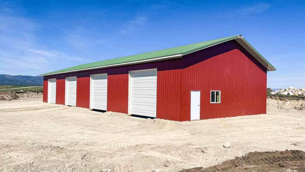 A 40x100x14 Hay and Ag Equipment Storage, featuring rural red metal siding, and medium green metal roofing, available for custom build by MQS, with permit assistance in MT