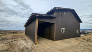 A 40x64x16 Bardominium shell and attached Garage, with multiple Lean-Tos, Built By MQS, Featuring Gray Metal Siding, And Black Metal Roofing, in Stevensville, Montana