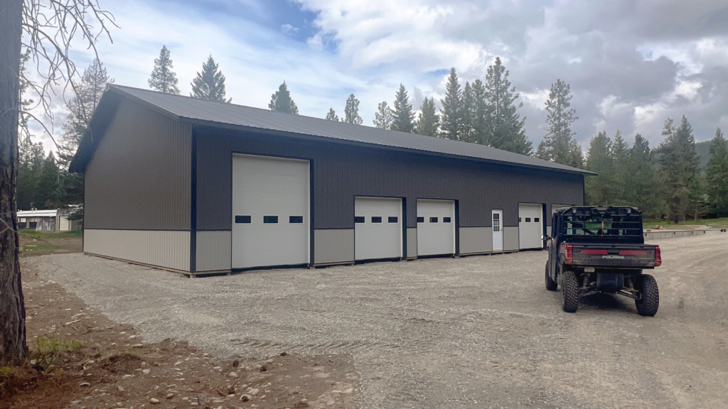 A 50x80x14 Multi Car Vehicle Storage Garage pole barn, Featuring Dark Gray Metal Siding, Black Metal Roofing, and Gray Wainscoting, available for custom build by MQS, with permit assistance in MT