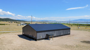 A 60x100x16 Barndominium Shell_Shop, featuring Dark Grey Metal Siding, And Black metal Trim and Roofing, Built By MQS in Helena, MT