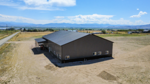 A 60x100x16 Barndominium Shell_Shop, featuring Dark Grey Metal Siding, And Black metal Trim, wainscoting, and Roofing, Built By MQS in Helena, MT