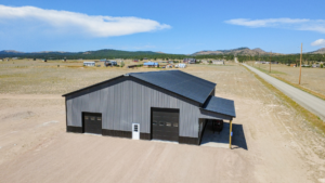 A 60x100x16 Barndominium Shell_Shop, featuring Dark Grey Metal Siding, And Black metal Wainscoting and Roofing, Built By MQS in Helena, MT