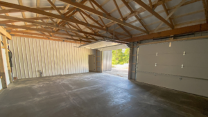 Interior of a 24x32x10 Pole barn Garage attaching to 28x32x18 Barndominium shell, featuring Dark Grey Metal Siding and Dark Grey Metal Roofing, and Built by MQS in Bayview, ID