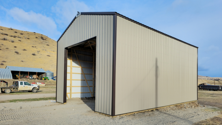 A 24x36x16 Commercial Feed Truck Storage pole barn, built by MQS, featuring taupe metal siding, and dark brown metal roofing, in Norris, MT